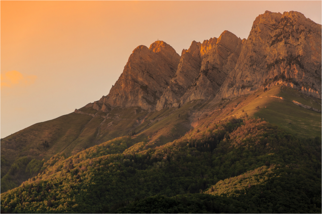 Photographie de la Dent d'Arclusaz au coucher du soleil dominant la Combe de Savoie sous un ciel aux couleurs flamboyantes.