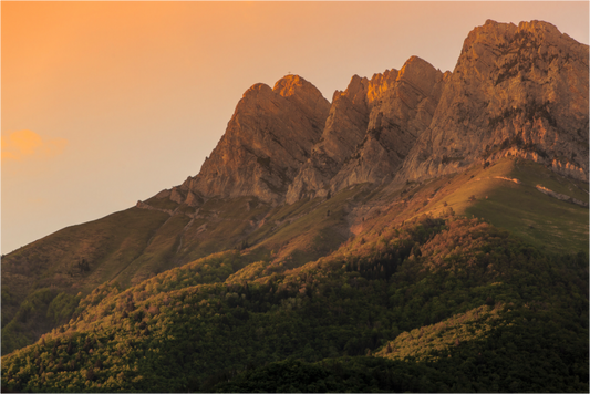Photographie de la Dent d'Arclusaz au coucher du soleil dominant la Combe de Savoie sous un ciel aux couleurs flamboyantes.