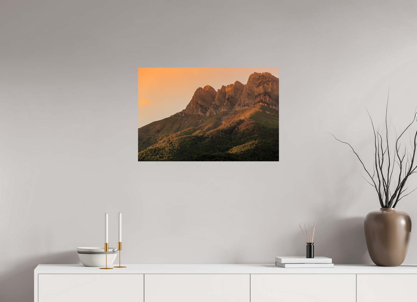 Les arêtes de la Dent d'Arclusaz se détachent dans un ciel orangé au-dessus des vignobles savoyards.