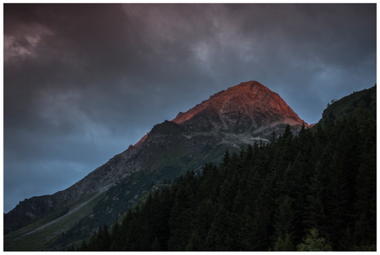 Les derniers rayons du soleil illuminent les sommets dominant la vallée de Champagny en Savoie.